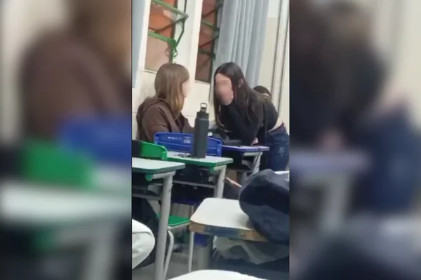Imagem colorida de duas alunas dentro de uma sala de aula, antes da confusão com tesouradas - Metrópoles