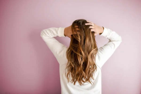 mulher passa as mãos no cabelo