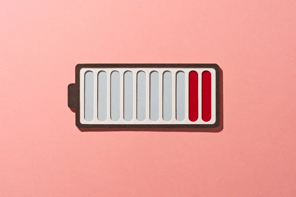 Ilustração colorida com tons de vermelho que simula uma bateria de celular - Metrópoles.