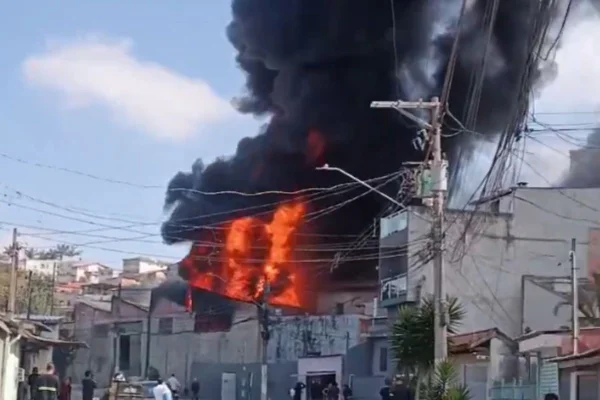 Imagem colorida mostra as chamas do incêndio em uma fábrica de colchões de SP. Metrópoles