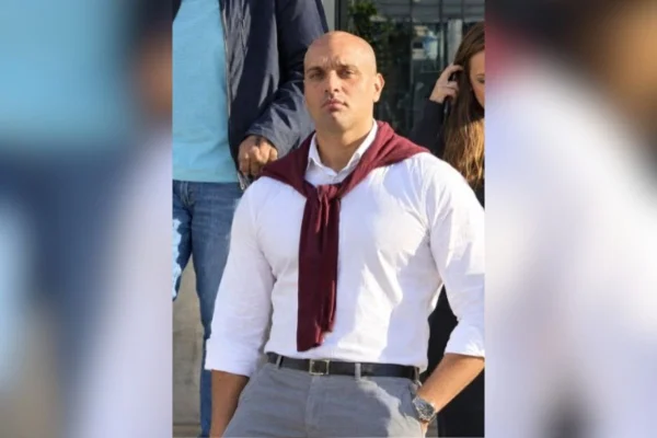 Foto colorida de homem posando com mãos no bolso.