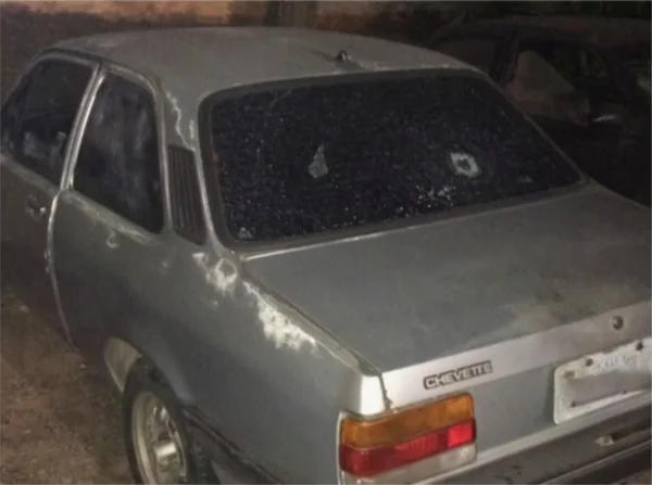 Imagem colorida de carro cinza com vidro traseiro baleado - Metrópoles