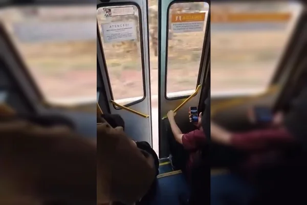 Foto colorida mostra ônibus circulando com porta aberta
