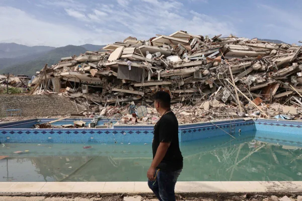 Homem caminha entre os escombros de prédios demolidos após um terremoto de magnitude 7,2 atingir a Venezuela - Metrópoles