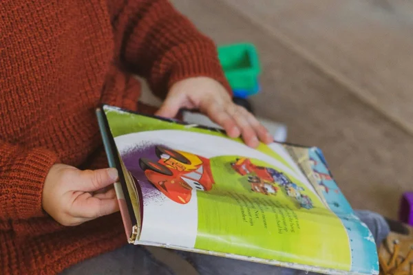 Criança manuseando livro infantil