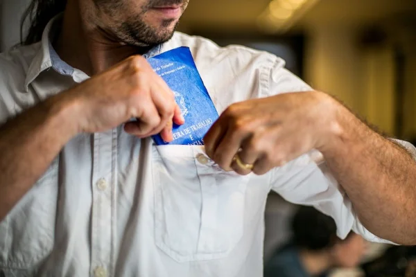 Homem com carteira de trabalho - Metrópoles