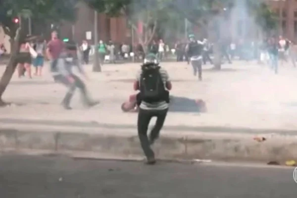 Foto colorida de cinegrafista caído no chão após ser atingido por rojão - Metrópoles