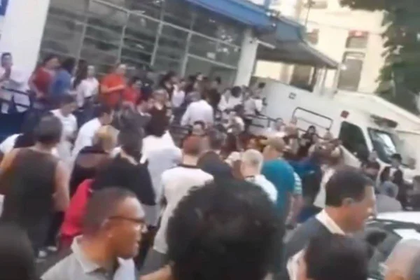 Homem que invadiu escola e foi contido por pais. Na imagem, aglomeração de pessoas - Metrópoles