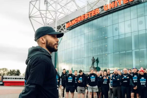 Foto colorida de Joe Thompson, em frente ao Old Trafford, casa do Manchester United - Metrópoles