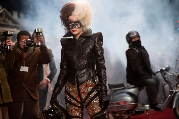 Emma Stone no filme Cruella, usando jaqueta de couro preta e calça brilhante