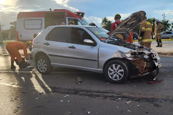 Carro amassado na frente e bombeiros ao redor