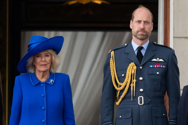 Foto colorida de mulher com roupa azul ao lado de homem com trajes militares - Metrópoles