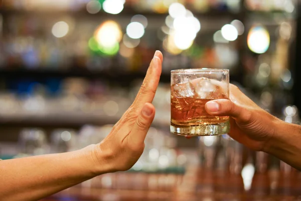 Imagem colorida de mão branca recusando copo de bebida alcoólica. Metanol em bebida é incolor e inodoro: perita aponta do que suspeitar. - Metrópoles