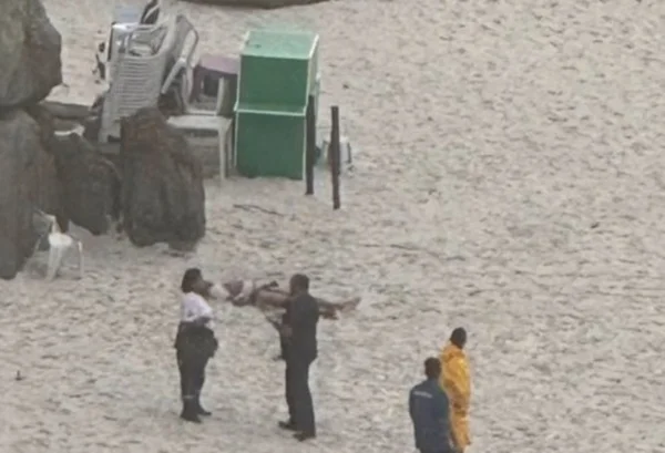 Imagem colorida de corpo de homem na areia - Metrópoles
