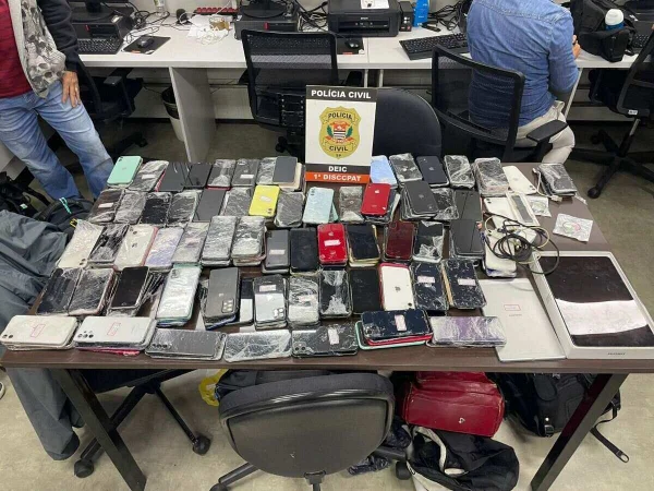 Foto colorida mostra aparelhos apreendidos pela Polícia Civil sobre uma mesa.