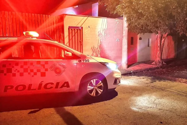 Imagem colorida de carro da PM em frente de uma residência. Metrópoles