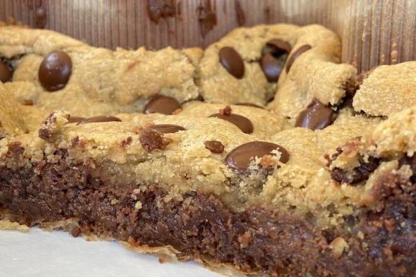 Na foto vemos uma torta com base de brownie e topo de cookie e recheio de Nutella