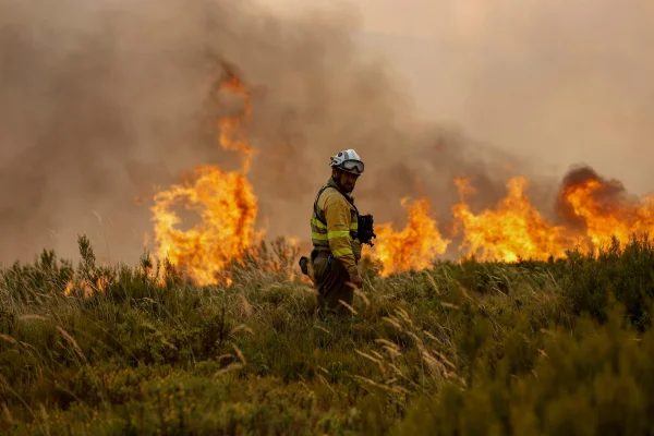 Bombeiro trabalha para extinguir um incêndio florestal em Goudiña, na Espanha