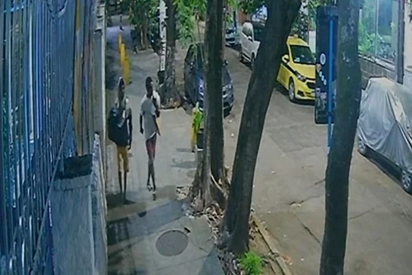imagem colorida de imagens que mostram homens abrindo bueiro horas antes de mulher cair no Rio de Janeiro