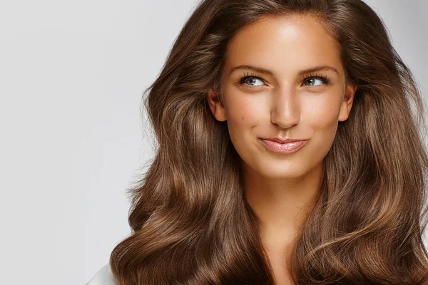 Mulher jovem com cabelo e pele brilhantes