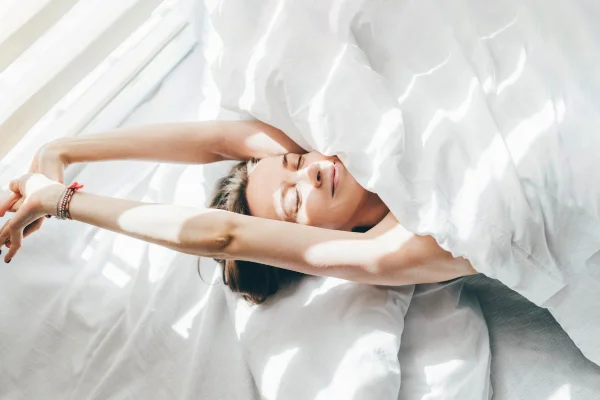 imagem colorida de uma mulher branca deitada em uma cama