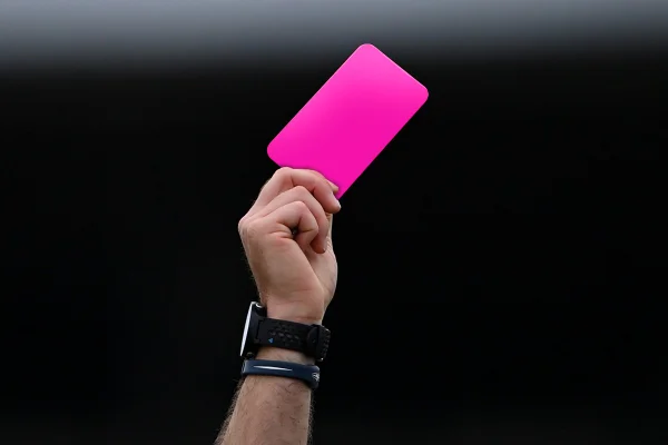Imagem mostra mão segurando um cartão cor de rosa para o alto