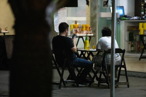 Dois homens sentados em bar