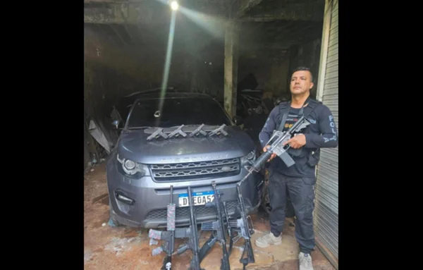 Policial ao lado de blindado