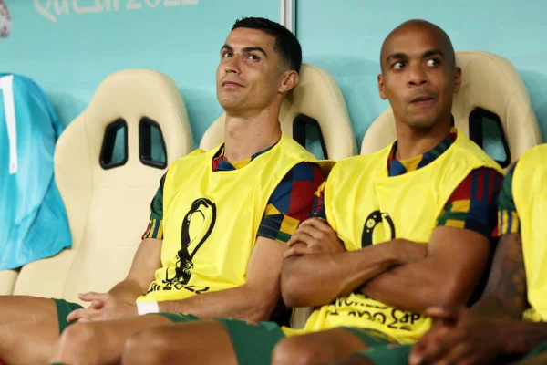 Cristiano Ronaldo e João Mário, jogadores de Portugal, aparecem sentados no banco de reservas e com colete amarelo durante jogo contra a Suíça, na Copa do Mundo do Catar - Metrópoles