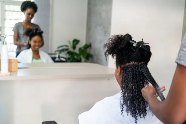 Foto colorida de uma pessoa fazendo cabelo no salão de beleza - Metrópoles
