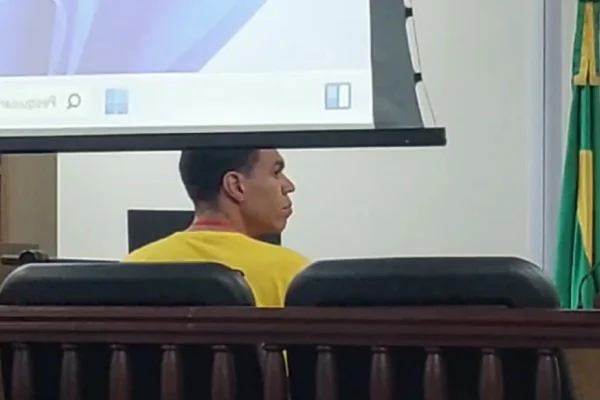 Imagens coloridas mostram perfil de homem, vestindo camiseta amarela, sentado e olhando para a direita. O soldado PM Luan Felipe Alves Pereira passou por audiência de custódia no TJM