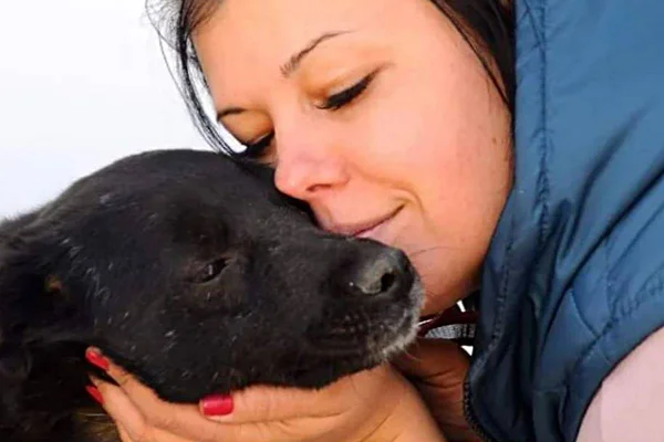 mulher segurando cachorro com rosto encostado no dele