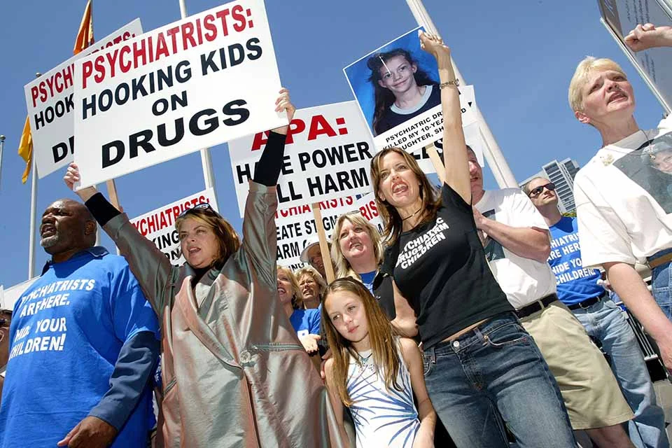 A atriz Kirstie Alley (à esquerda) e a atriz Kelly Preston (à direita) lideram manifestantes em uma marcha contra a American Psychiatric Association (APA), em 19 de maio de 2003, em San Francisco, Califórnia. Centenas de manifestantes marcharam para a convenção anual da American Psychiatric Association para expressar suas opiniões sobre psiquiatras em uso de quimioterapia para crianças em idade escolar A atriz Kirstie Alley (à esquerda) e a atriz Kelly Preston (à direita) lideram manifestantes em uma marcha contra a American Psychiatric Association (APA), em 19 de maio de 2003, em San Francisco, Califórnia. Centenas de manifestantes marcharam para a convenção anual da American Psychiatric Association para expressar suas opiniões sobre psiquiatras em uso de quimioterapia para crianças em idade escolar