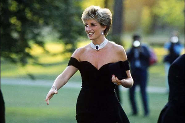 Foto colorida de uma mulher loira usando um vestido preto
