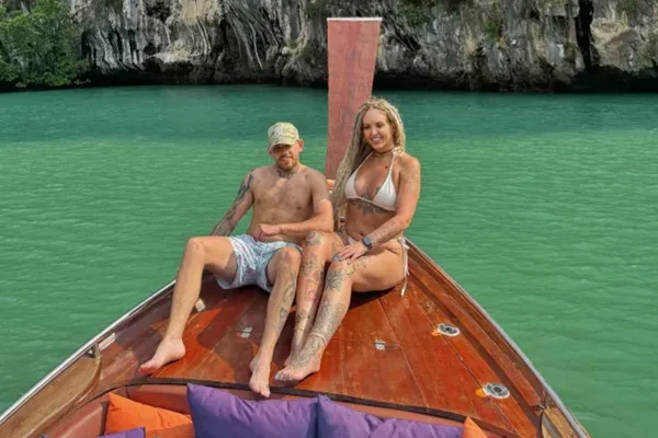 Foto colorida de casal em barco no mar