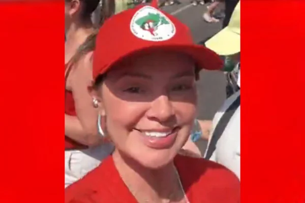 Mulher branca com boné vermelho do MST e camiseta da mesma cor - Metrópoles