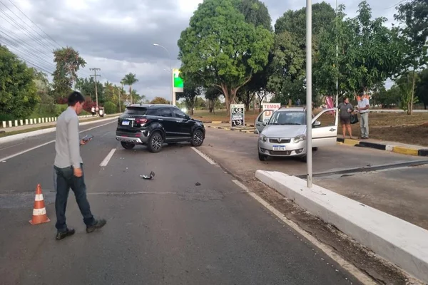 homem andando em frente a carros batidos