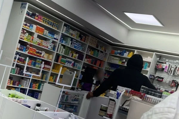 Foto colorida de homem dentro de farmácia momentos antes de atirar contra a ex-companheira dentro de uma farmácia.