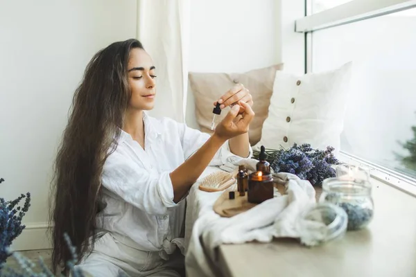 Na foto, uma mulher passando óleos no corpo - Metrópoles