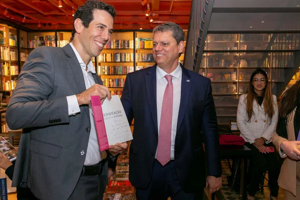 foto colorida do secretário Renato Feder ao lado do governador Tarcísio de Freitas (ambos de terno) em uma livraria - Metrópoles