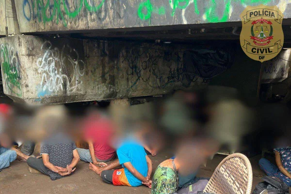 Foto de suspeitos sentando com as mãos para trás das costas