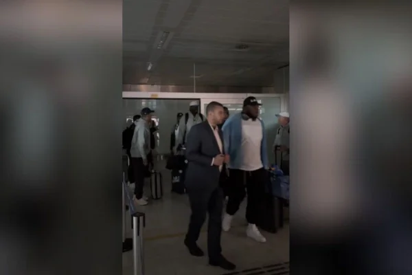 Imagem colorida mostra jogadores do Los Angeles Chargers desembarcando no aeroporto de Guarulhos, em São Paulo, durante apagão no local - Metrópoles