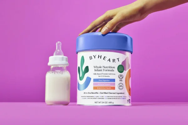 Imagem do produto que é uma fórmulainfantil de leite da marca Byheart em fundo rosa. Metrópoles