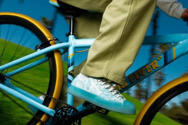 Tênis azul com estampa de cobra em pedal de bicicleta