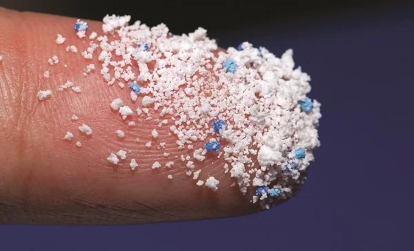 foto em zoom de um dedo coberto por resíduos plásticos