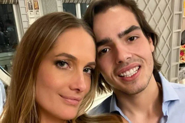 Foto colorida de João Guilherme sorrindo ao lado da namorada modelo - Metrópoles