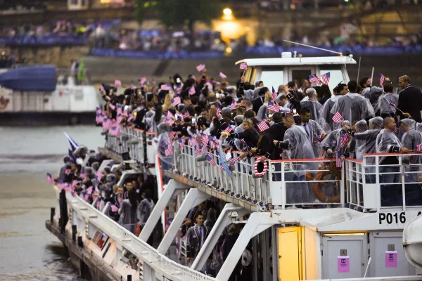 PARIS, FRANÇA - 26 DE JULHO: Atletas da delegação dos EUA navegam em um barco ao longo do rio Sena enquanto a chuva começa no início da cerimônia de abertura dos Jogos Olímpicos de Paris 2024 em Paris, França, em 26 de julho de 2024.