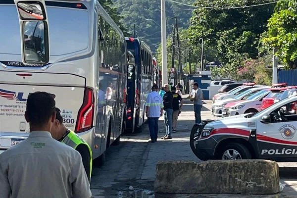 Fotografia colorida de ônibus sendo fiscalizado na entrada do Guarujá, durante semana de Réveillon - Metrópoles