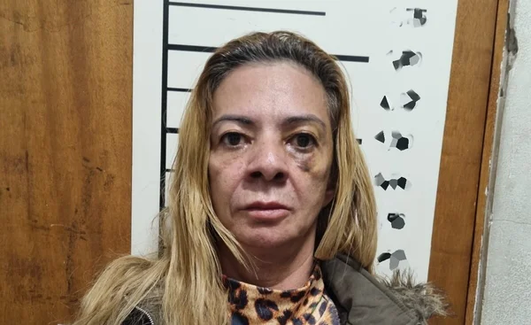 Em foto colorida mulher branca, de meia idade, com cabelos loiros tingidos, com raízes castanho escuro aparecendo na franja liderança do PCC - Metrópoles