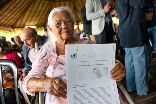 Fotografia colorida de um trabalhador rural recebendo o CDU em evento da ETR